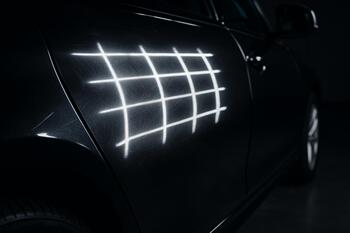 Grid lights exposing micro-defects on a black panel